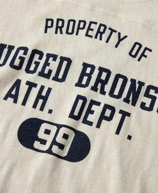 Cream T-shirt with navy text logo: Rugged Bronson Ath. Dept. 99