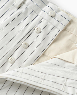 White pinstripe pants close-up of waistband buttons and pleated front