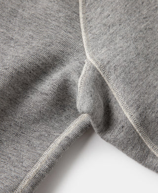 Gray raglan sweater sleeve end with ribbed cuff and seam detail.