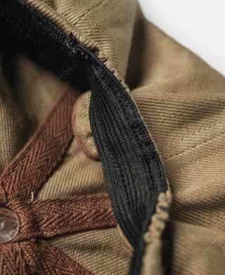 Khaki biker cap side with black strap-like trim and brown patch seam.