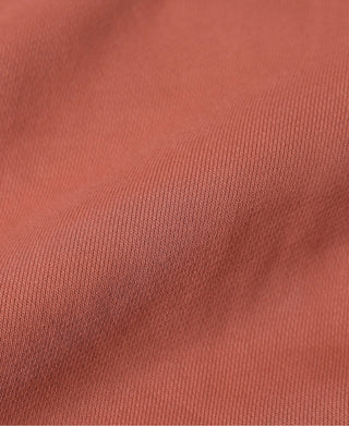 Brick red terry cloth full-zip hoodie fabric close-up, textured knit surface