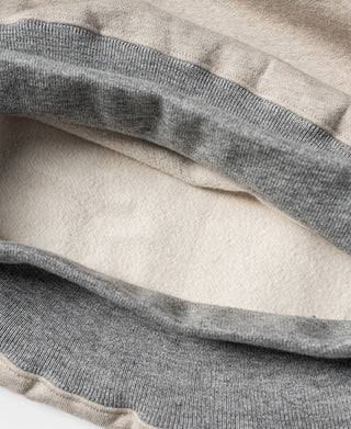 Oatmeal sweatshirt hem with gray ribbed band and layered stitching detail