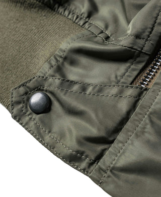 Olive flight jacket pocket flap with snap button and reinforced stitching