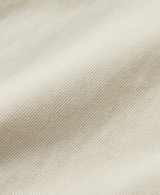 Light cream henley shirt knit fabric close-up with fine texture