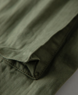 Olive fatigue trousers close-up of hem fold and inner seam.