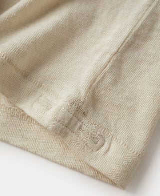 Cream T-shirt hem fold with textured fabric detail close-up