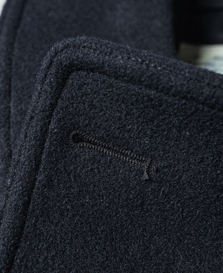 Navy peacoat shoulder seam and stitched pocket flap detail