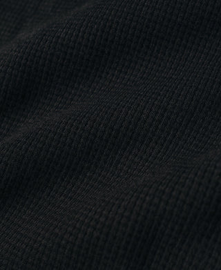 Black waffle-knit fabric texture close-up