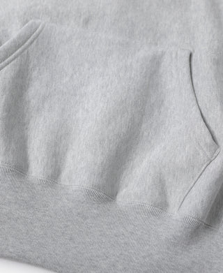 Gray hoodie hem with ribbed cuffs and side seam detail, close-up