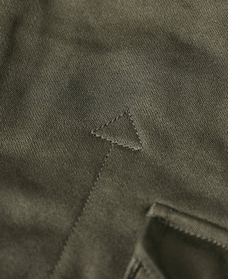 Olive field jacket close-up of fabric patch marking and reinforced stitching