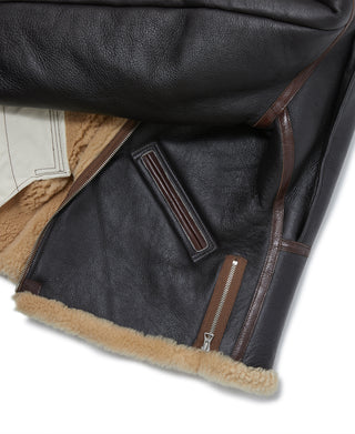 Dark leather flight jacket with brown zipper and cream shearling hem