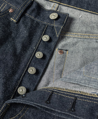 Indigo denim jeans close-up of button fly placket and coin pocket.