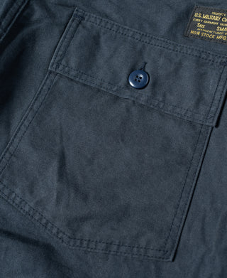 Navy cargo pocket close-up with flap button and embroidered label patch