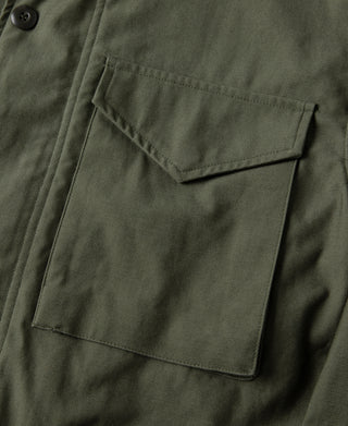Olive field jacket chest pocket with flap, side seam stitching, and button