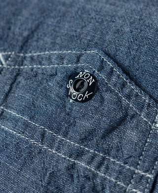 Blue chambray work shirt chest pocket with round logo patch