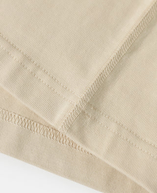 Apricot cotton T-shirt hem with stitched edge and fine weave detail