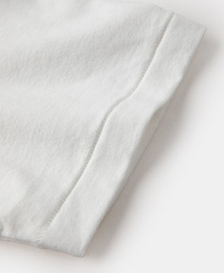 White tubular athletic t-shirt sleeve, close-up of stitched hem and seam.