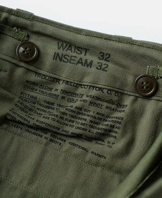 Olive field trousers with waistband label and button fly closure