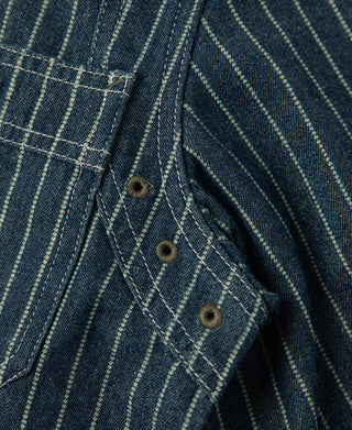 Indigo striped pocket flap detail with two dark buttons and topstitching