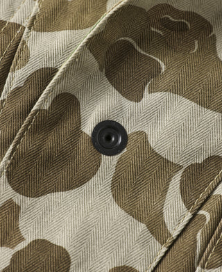 Camo jacket detail showing textured fabric and round black button.