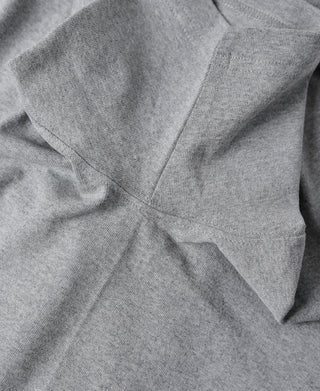 Gray cotton tubular T-shirt shoulder seam and pocket-style front detail close-up.