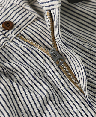 Close-up of striped pants zipper with gold-trim teeth and pull