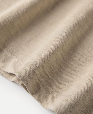 Light tan T-shirt hem with stitched edge close-up