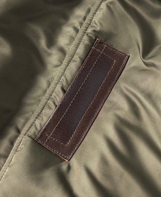 Olive N-3 parka with brown leather brand tab on the chest area.
