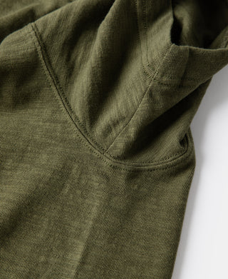 Green cotton T-shirt side seam with tubular gusset at hem