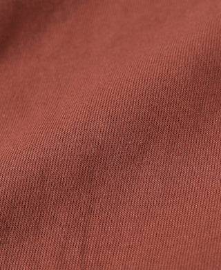 Brick red henley T-shirt fabric close-up with fine knit texture