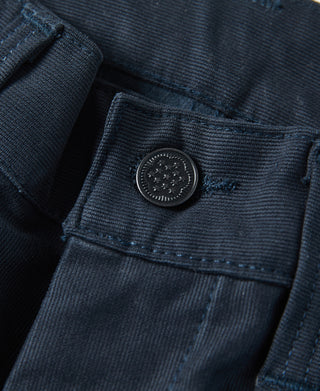 Navy deck pants waistband close-up with round button and stitched seam detail.
