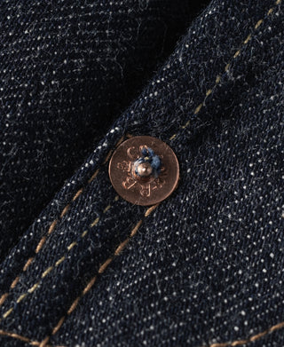 Indigo denim riveted pocket with copper-tone button and yellow topstitching