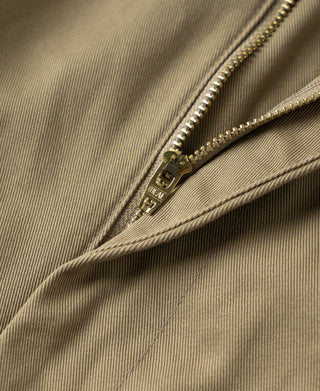 Khaki trousers close-up of zipper fly and metal hardware.