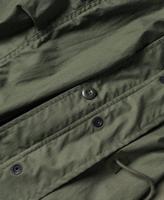 Olive M-65 parka front button placket with small metal buttons and tie closure