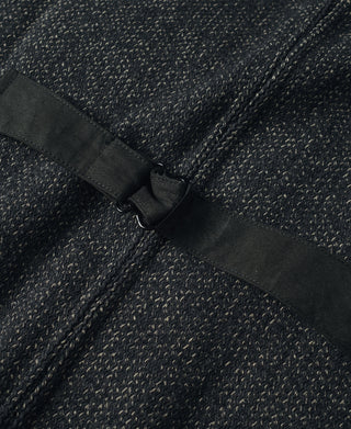 Fabric belt strap with black buckle on dark wool vest