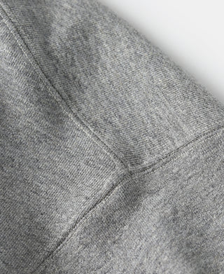 Hooded sweatshirt hem close-up, gray fabric with navy pocket panel and stitching