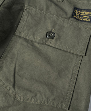Olive utility shorts close-up of front pocket flap with round button