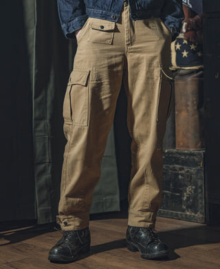 Khaki field pants on model, front view showing flap cargo pockets and seams.
