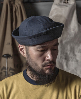 Navy Dixie Cup hat worn by a bearded man, front three-quarter view