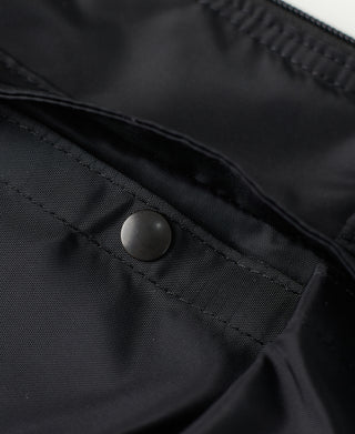 Black nylon helmet bag pocket with round snap button and stitched paneling