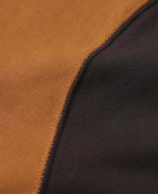 Close-up of orange body and dark contrast sleeve seam on quarter-zip long-sleeve T-shirt