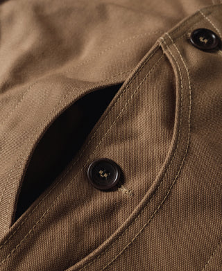 Khaki canvas hunting vest pocket flap with dark button closure