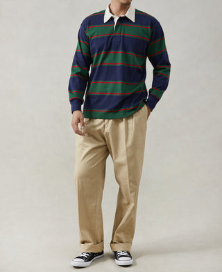 Mens rugby shirt worn with tan pants and sneakers; navy with green/red striped design