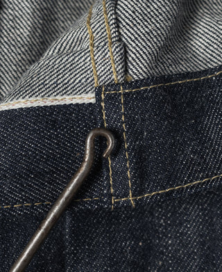 Indigo denim jacket hardware close-up with metal loop and topstitching