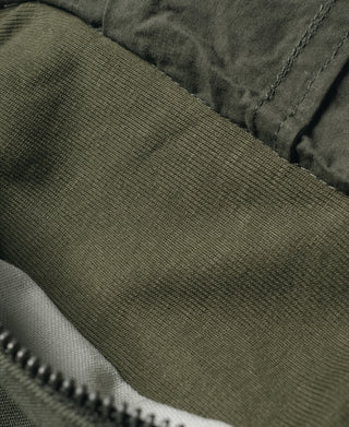 Olive ripstop fabric panel with stitched seam and textured weave close-up.
