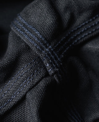 Navy canvas seam close-up with cross-stitching and textured fabric weave