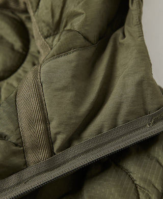 Olive quilted jacket hem with elastic binding and adjustable strap detail