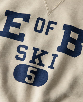 Cream ski sweatshirt front with blue text and “5” graphic