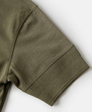 Olive henley t-shirt sleeve cuff and side seam close-up