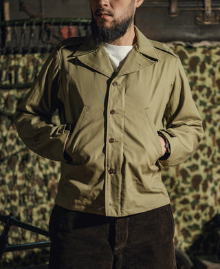Olive green field jacket with pointed collar and buttoned chest pocket